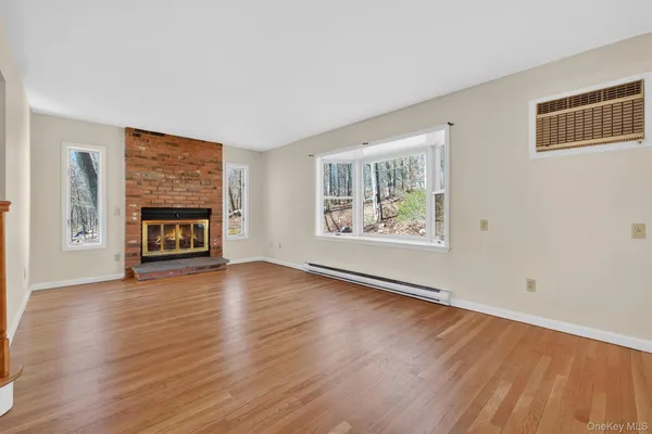 wooden floor fireplace and windows in an empty room