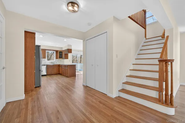 a view of a livingroom with wooden floor and stairs