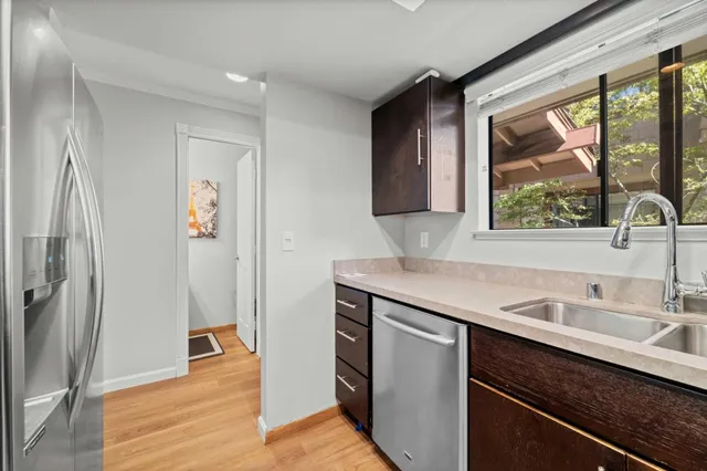 a view of a sink a refrigerator and a window