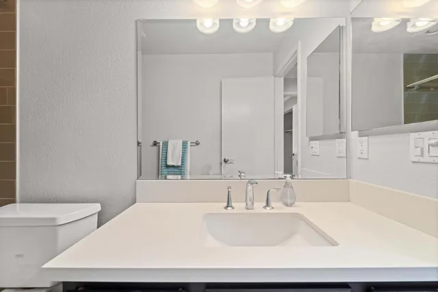 a bathroom with a sink a toilet and a large mirror