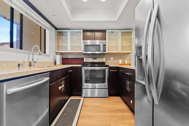 a kitchen with stainless steel appliances granite countertop a refrigerator a sink a stove and island