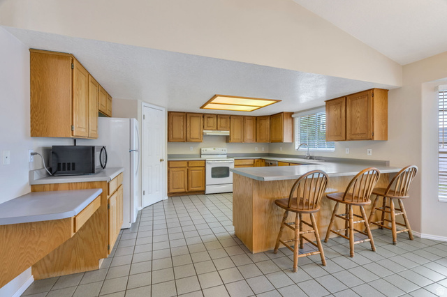 886 West 1700th Street North Mapleton, UT 84664 - Photo 5 of 21 Spacious kitchen featuring extensive cabinetry, tile flooring, a large island with integrated seating, and a built-in oven range