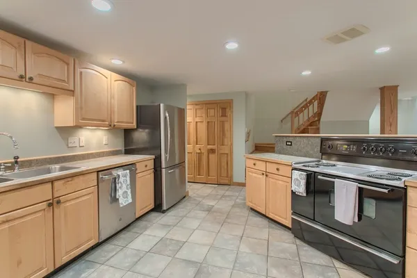 a kitchen with stainless steel appliances granite countertop a stove a sink and a refrigerator