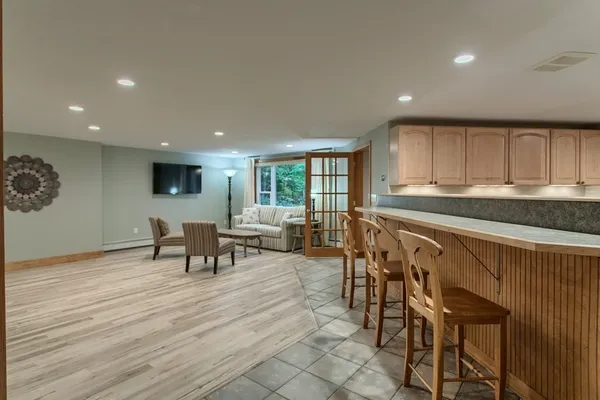 a kitchen with stainless steel appliances granite countertop a stove a sink a dining table and chairs with wooden floor