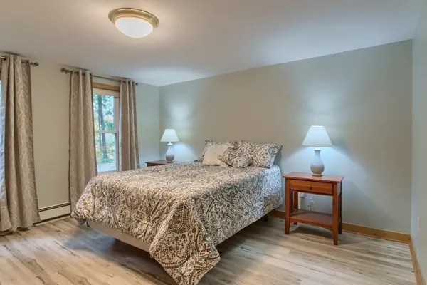 a bedroom with a bed and wooden floor