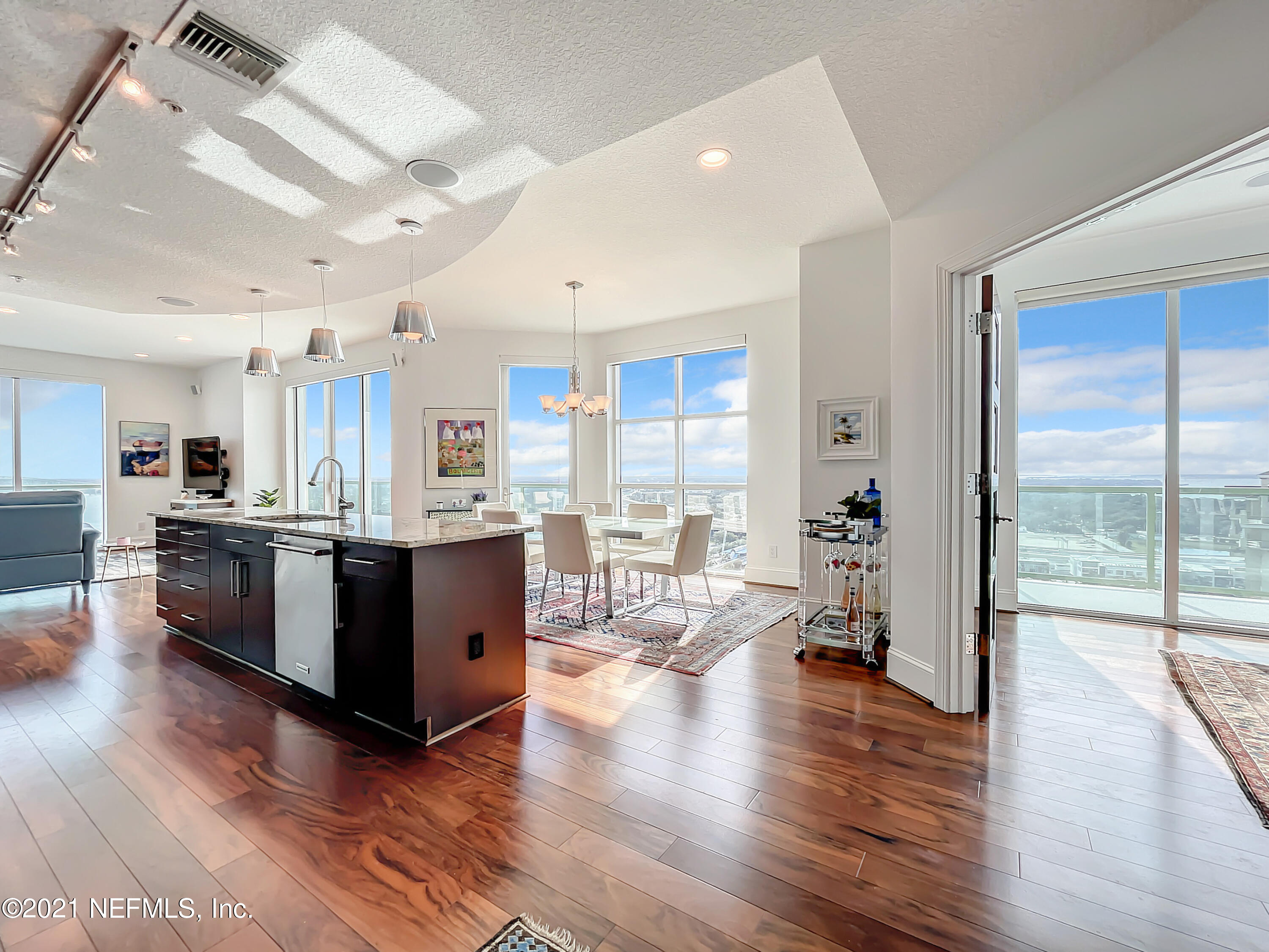 a large open kitchen with a large window a island and stainless steel appliances