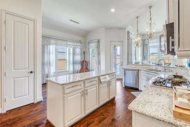 a kitchen with kitchen island granite countertop a stove sink and refrigerator