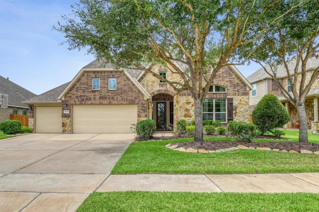 a front view of a house with a yard and tree