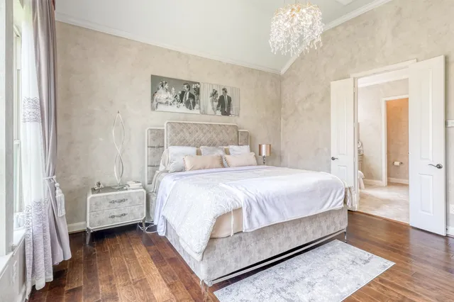 a spacious bedroom with a bed and a chandelier