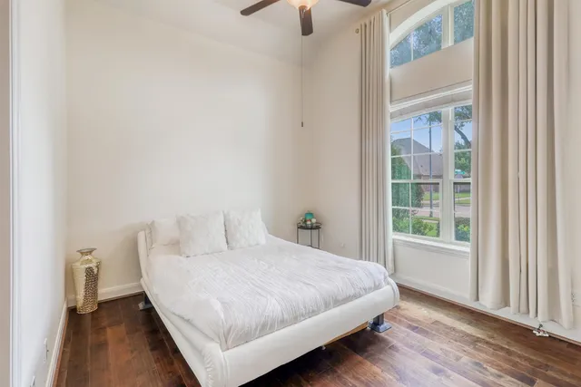 a bedroom with a bed and wooden floor