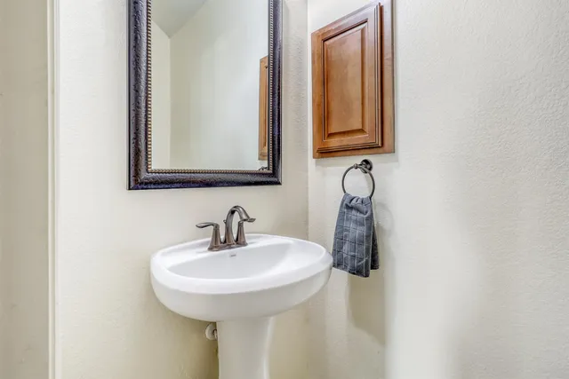 an empty room with a chandelier fan and wooden floor