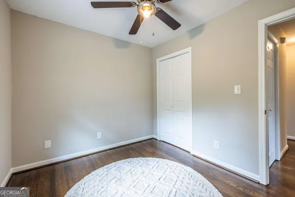 an empty room with a ceiling fan and wooden floor