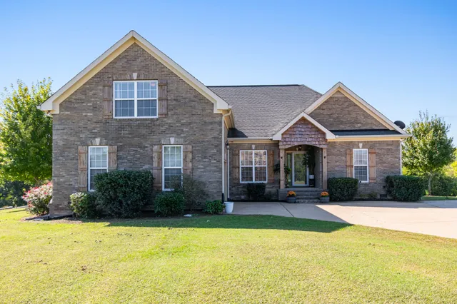 a front view of a house with yard and garage