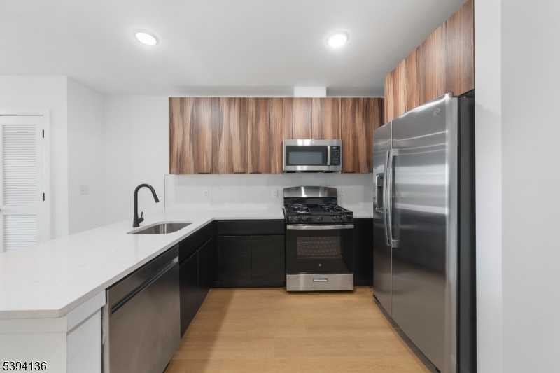 768 Bergen Street, Unit 5D Newark, NJ 07108 - Photo 2 of 14 a kitchen with a refrigerator sink and stainless steel appliances