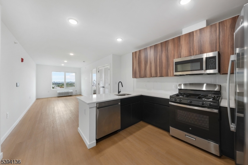 768 Bergen Street, Unit 5D Newark, NJ 07108 - Photo 3 of 14 a kitchen with granite countertop a stove and a microwave