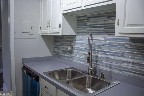 a kitchen with granite countertop white cabinets and stainless steel appliances