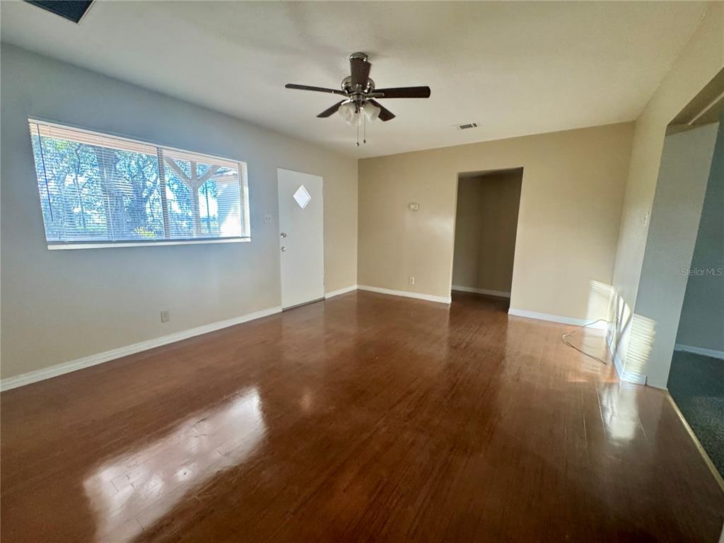 1516 Hawk Griffin Road Plant City, FL 33563 - Photo 11 of 17 a view of a livingroom with wooden floor and a ceiling fan