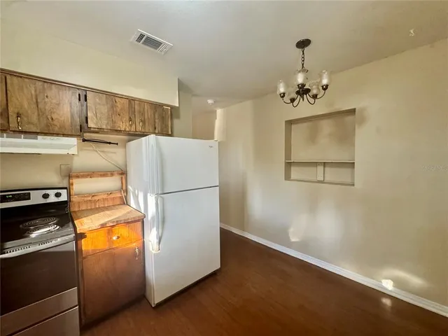 a view of a livingroom with wooden floor and a ceiling fan