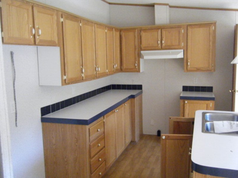 203 Creek Valley Road Stuart, VA 24171 - Photo 2 of 6 a kitchen with stainless steel appliances granite countertop a sink a stove and white cabinets with wooden floor