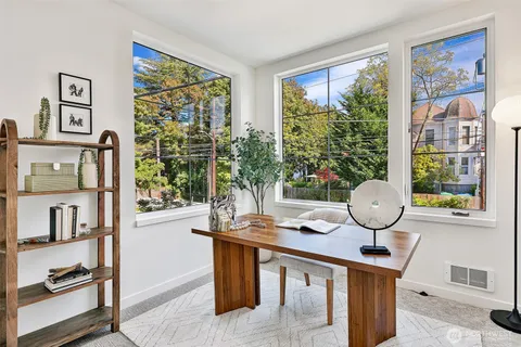 a view of a workspace room with furniture and window