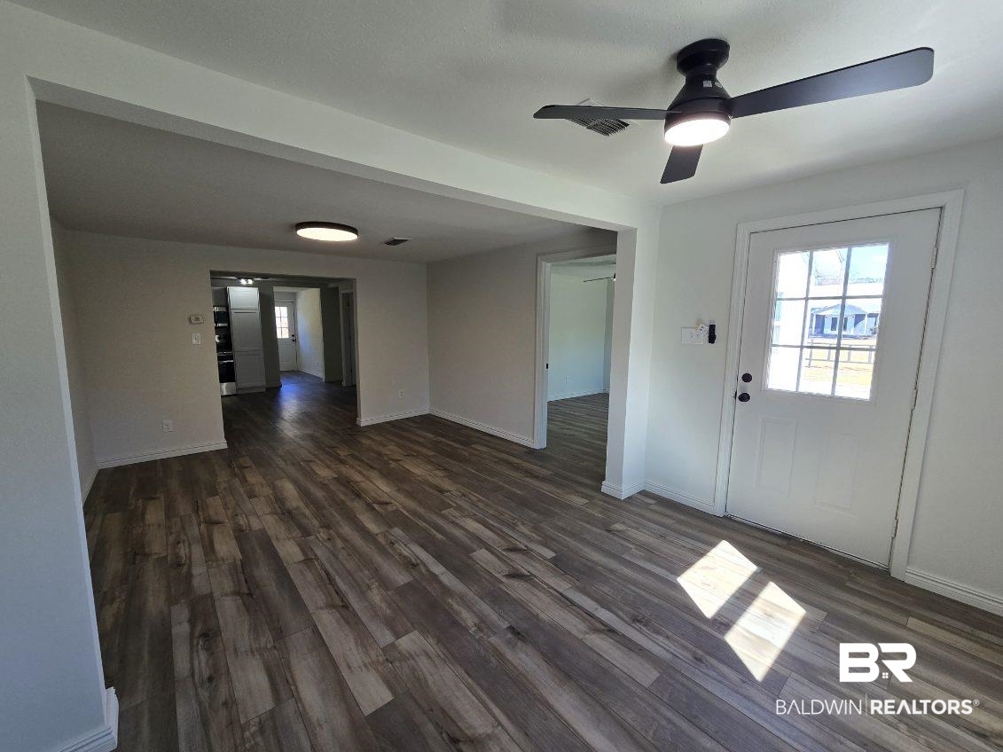 821 Dailey Street Brewton, AL 36426 - Photo 10 of 17 Unfurnished living room with dark wood finished floors and a ceiling fan