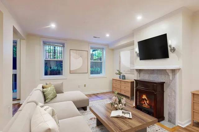 a living room with furniture a fireplace and a flat screen tv