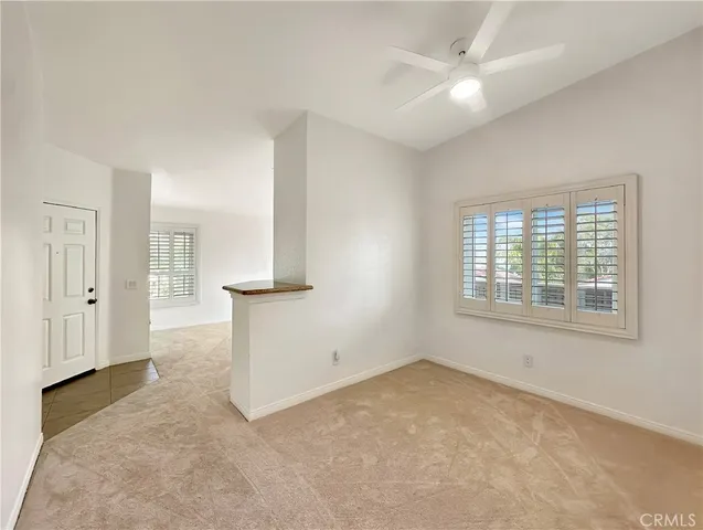 an empty room with a window and a ceiling fan