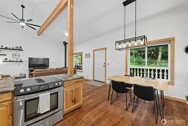 a room with kitchen island granite countertop wooden floor and stainless steel appliances