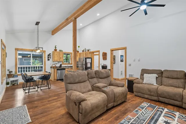 a living room with furniture kitchen view and a window