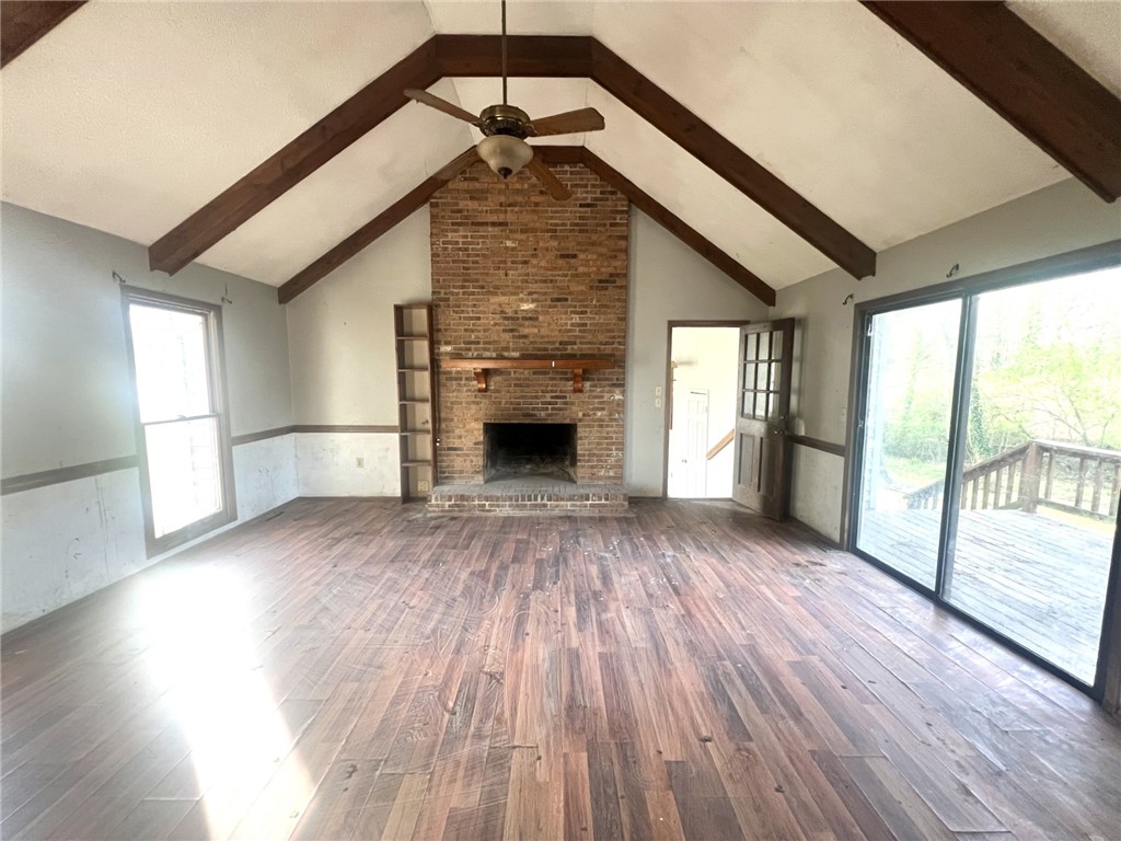 606 Timberlake Road Anderson, SC 29625 - Photo 5 of 12 This living room features vaulted ceilings, a brick fireplace, and direct access to an outdoor deck.