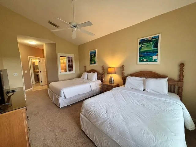 a bedroom with two beds and a chandelier