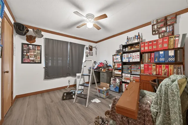 a view of a workspace with furniture and a book shelf