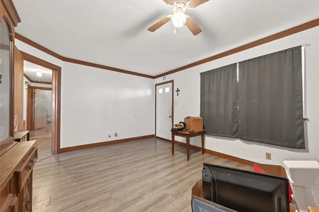 a view of an empty room with a window and wooden floor