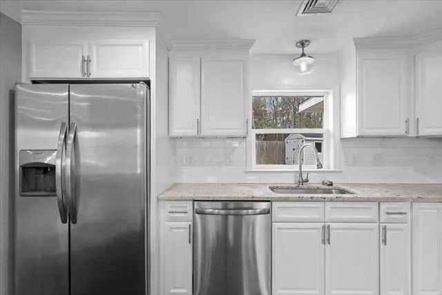 a view of kitchen with granite countertop white cabinets and counter space