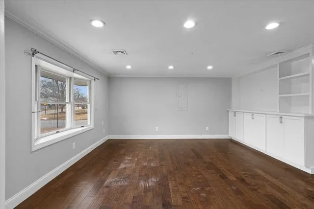 a view of an empty room with wooden floor