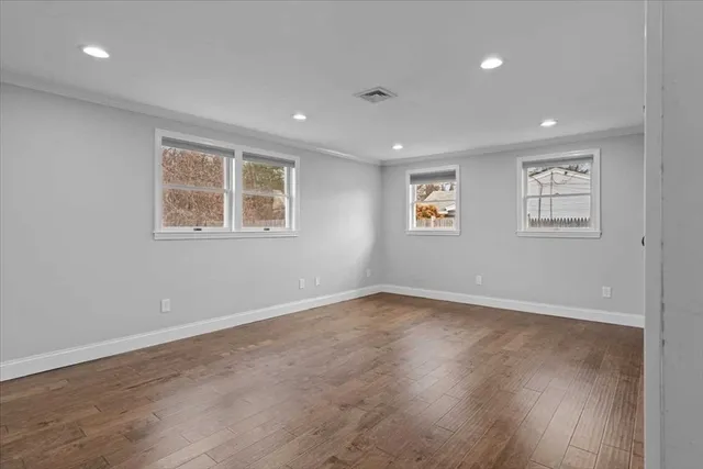 a view of empty room with wooden floor