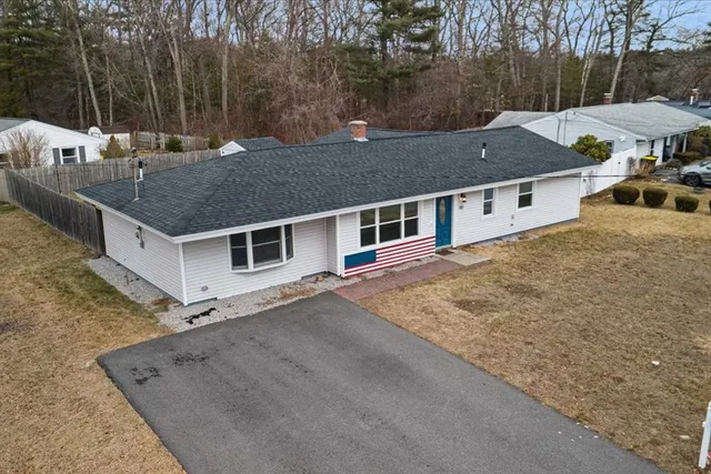an aerial view of a house with yard and trees