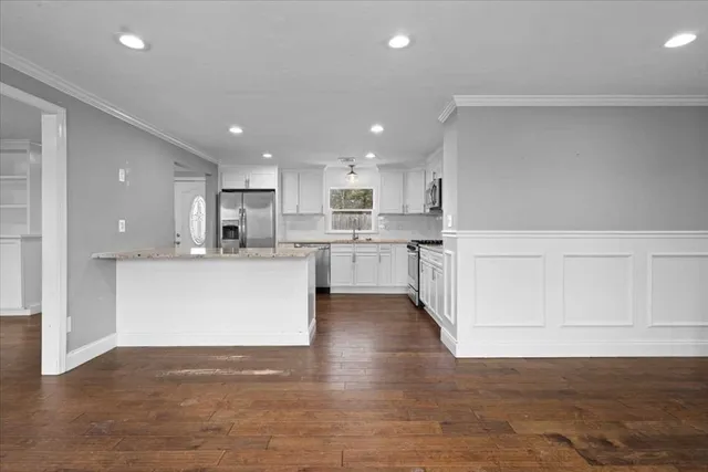 a large kitchen with stainless steel appliances lots of white cabinets