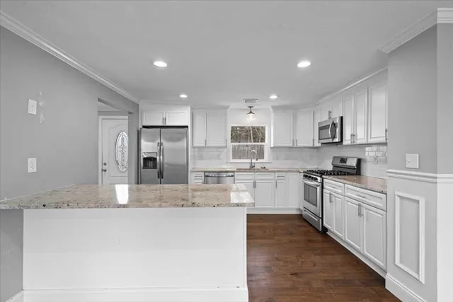 a kitchen with cabinets stainless steel appliances and sink