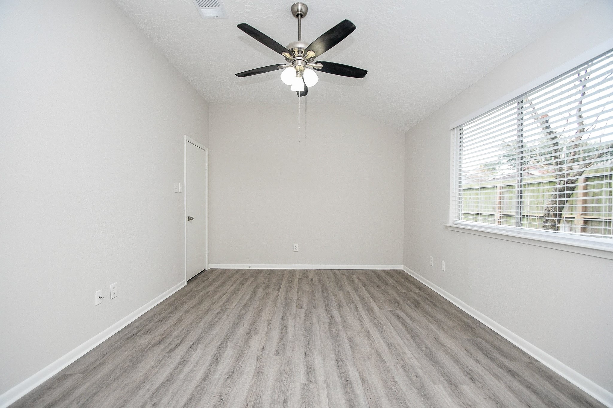 15315 Cedar Ridge Drive Houston, TX 77082 - Photo 11 of 20 an empty room with a window and a fan