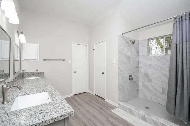 a view of empty room with wooden floor and window