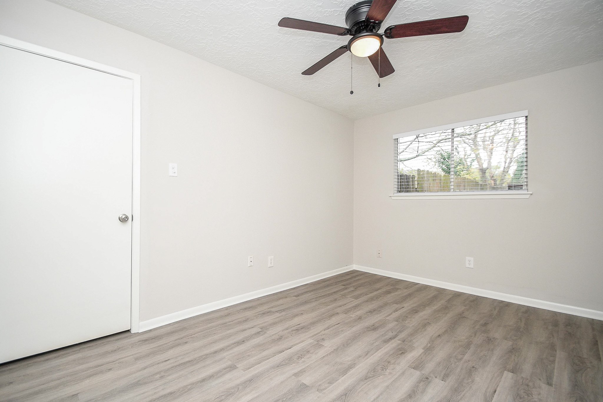 15315 Cedar Ridge Drive Houston, TX 77082 - Photo 17 of 20 an empty room with wooden floor ceiling fan and windows