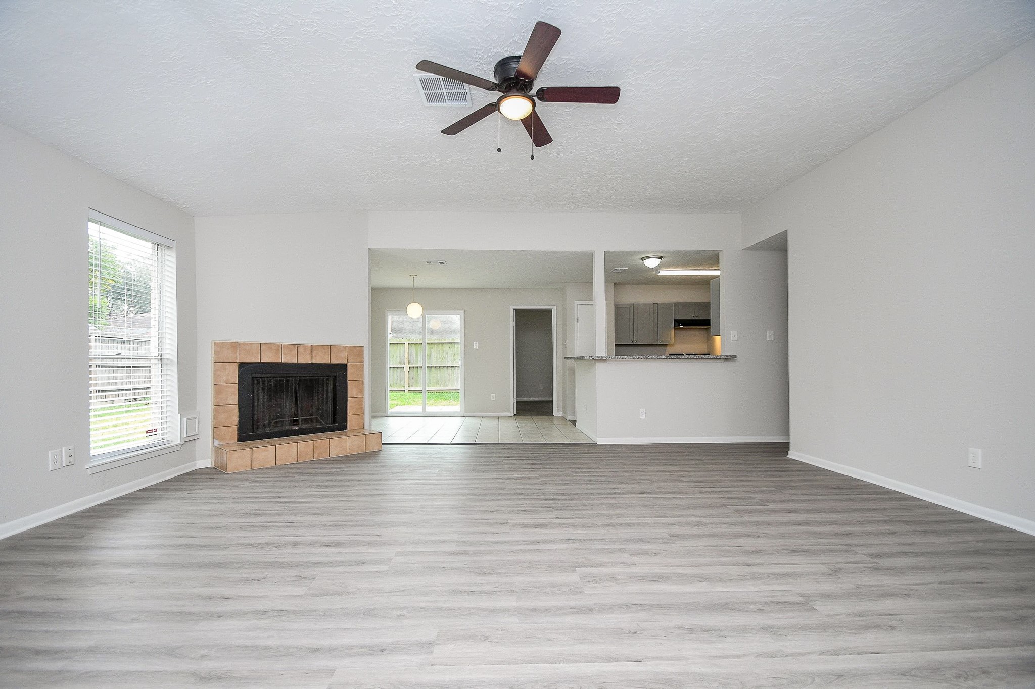 15315 Cedar Ridge Drive Houston, TX 77082 - Photo 2 of 20 a view of a livingroom with a fireplace a ceiling fan and windows