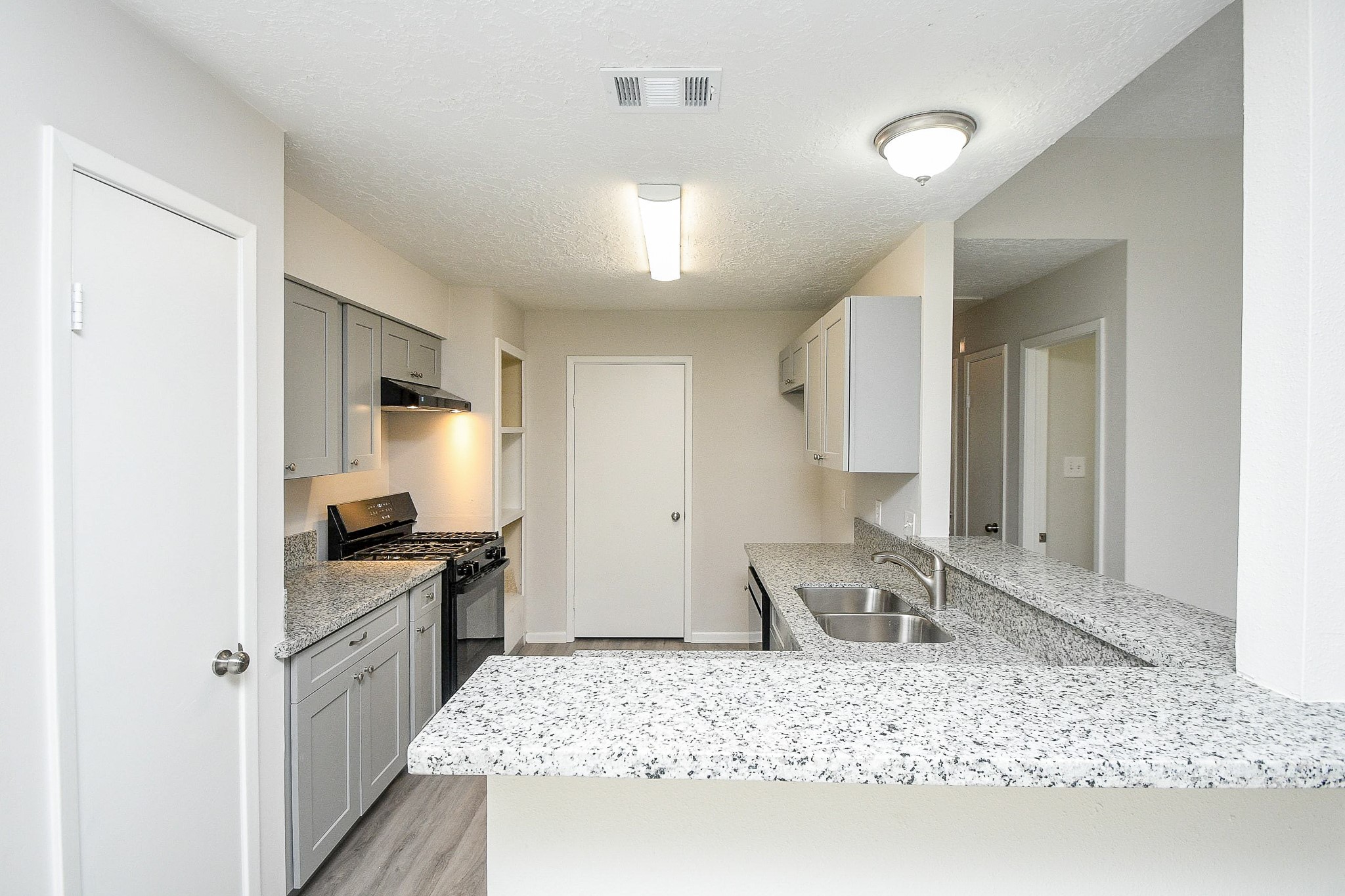 15315 Cedar Ridge Drive Houston, TX 77082 - Photo 6 of 20 a large kitchen with kitchen island granite countertop a sink stove and refrigerator