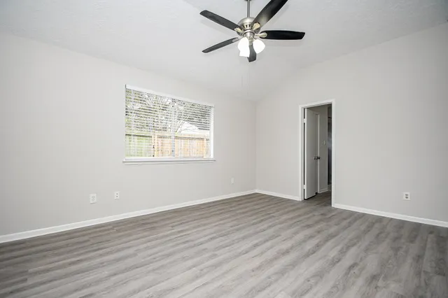 an empty room with a window and a fan