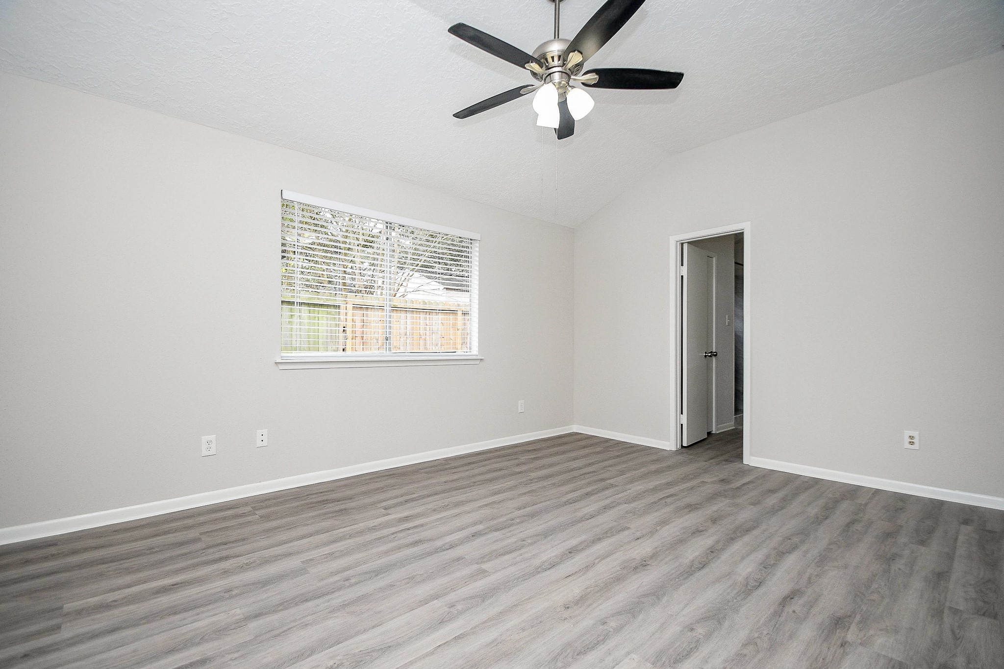 15315 Cedar Ridge Drive Houston, TX 77082 - Photo 10 of 20 an empty room with wooden floor fan and windows