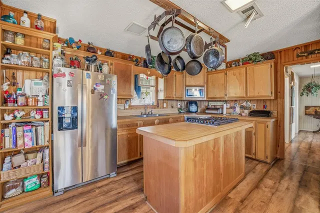 a kitchen with stainless steel appliances a sink a stove and a wooden floors