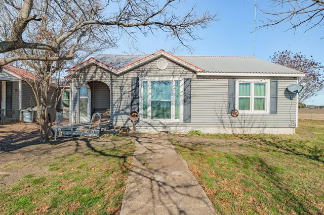 a front view of house with yard and trees around