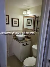 a bathroom with a granite countertop toilet sink and mirror