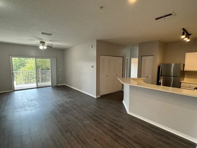 a view of a kitchen with wooden floor and a ceiling fan